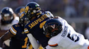 Nov 1, 2025; Berkeley, California, USA; Virginia Cavaliers linebacker Kam Robinson (5) sacks California Golden Bears quarterback Jaron-Keawe Sagapolutele (3) (obscured) during the second quarter at California Memorial Stadium. Mandatory Credit: D. Ross Cameron-Imagn Images