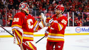 Calgary Flames goaltender Dustin Wolf celebrates a win with teammates after defeating Vegas Golden Knights.