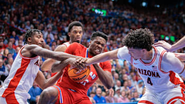 Mar 8, 2025; Lawrence, Kansas, USA; Kansas Jayhawks forward Flory Bidunga (40) protects the ball from Arizona Wildcats guard Liam Lloyd (11) and Arizona Wildcats forward Trey Townsend (4) during the second half at Allen Fieldhouse. Mandatory Credit: William Purnell-Imagn Images