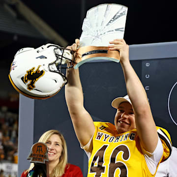 Wyoming Cowboys kicker John Hoyland celebrates with the MVP trophy after defeating the Toledo Rockets in the Arizona Bowl.