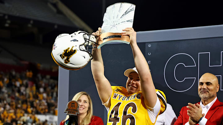Wyoming Cowboys kicker John Hoyland celebrates with the MVP trophy after defeating the Toledo Rockets in the Arizona Bowl.