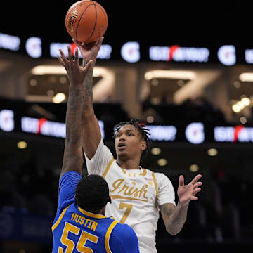 Mar 11, 2025; Charlotte, NC, USA; Notre Dame Fighting Irish forward Tae Davis (7) shoots a jumper over Pittsburgh Panthers forward Zack Austin (55) during the second half at Spectrum Center. 