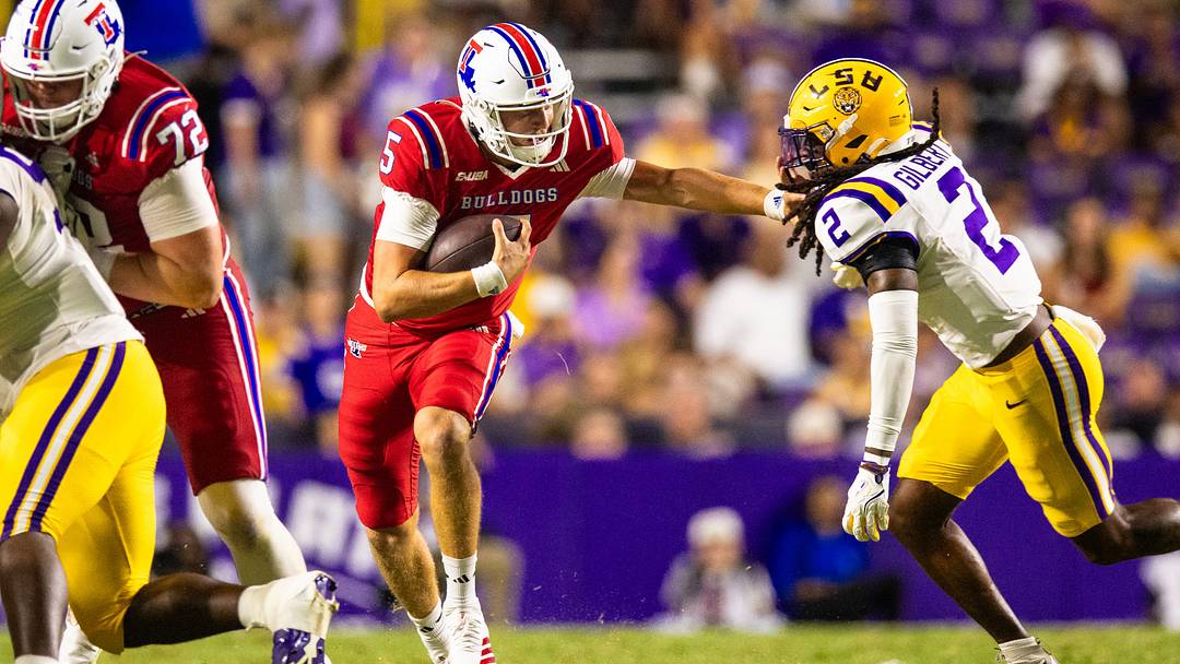 Sep 6, 2025; Baton Rouge, Louisiana, USA;  Louisiana Tech Bulldogs quarterback Blake Baker (5) scrambles against LSU Tigers safety Jardin Gilbert (2) during the second half at Tiger Stadium. Mandatory Credit: Stephen Lew-Imagn Images