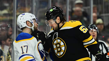Mar 17, 2025; Boston, Massachusetts, USA;  Boston Bruins defenseman Andrew Peeke (52) grabs a hold of Buffalo Sabres left wing Jason Zucker (17) during the second period at TD Garden. Mandatory Credit: Bob DeChiara-Imagn Images