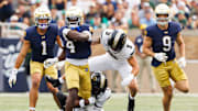 Purdue defensive back Smiley Bradford, bottom, tackles Notre Dame running back Jeremiyah Love (4) during the first half of a NCAA football game against Purdue at Notre Dame Stadium on Saturday, Sept. 20, 2025, in South Bend.