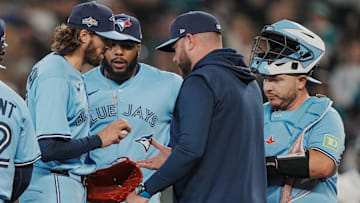 Oct 17, 2025; Seattle, Washington, USA; Toronto Blue Jays manager John Schneider (14) takes the ball from pitcher Kevin Gausman (34) in the sixth inning during game five of the ALCS round against the Seattle Mariners for the 2025 MLB playoffs at T-Mobile Park. Mandatory Credit: Stephen Brashear-Imagn Images