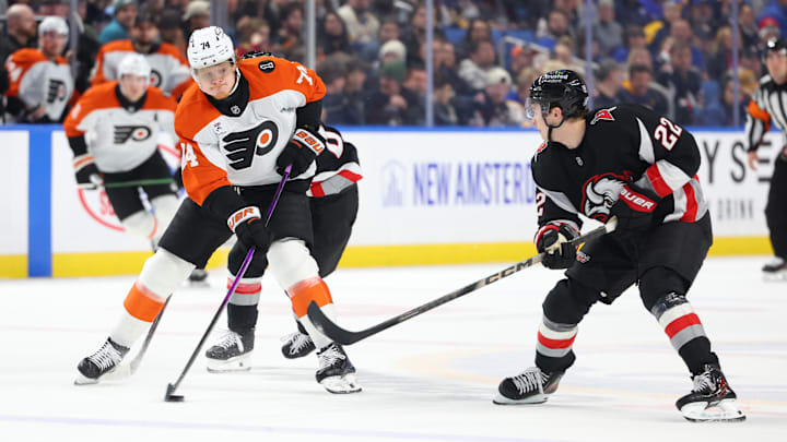 Dec 18, 2025; Buffalo, New York, USA;  Philadelphia Flyers right wing Owen Tippett (74) controls the puck as Buffalo Sabres right wing Jack Quinn (22) defends during the first period at KeyBank Center. Mandatory Credit: Timothy T. Ludwig-Imagn Images