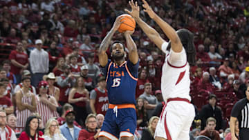 Dec 7, 2024; Fayetteville, Arkansas, USA;  Texas-San Antonio Roadrunners forward Jonnivius Smith (15) shoots over Arkansas Razorbacks forward Jonas Aidoo (9) during the first half at Bud Walton Arena. Mandatory Credit: Brett Rojo-Imagn Images
