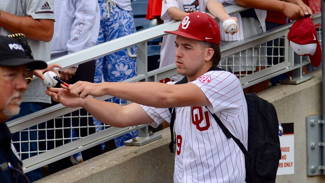 Oklahoma pitcher Cord Rager signs autographs before Game 2 of the CWS Finals.