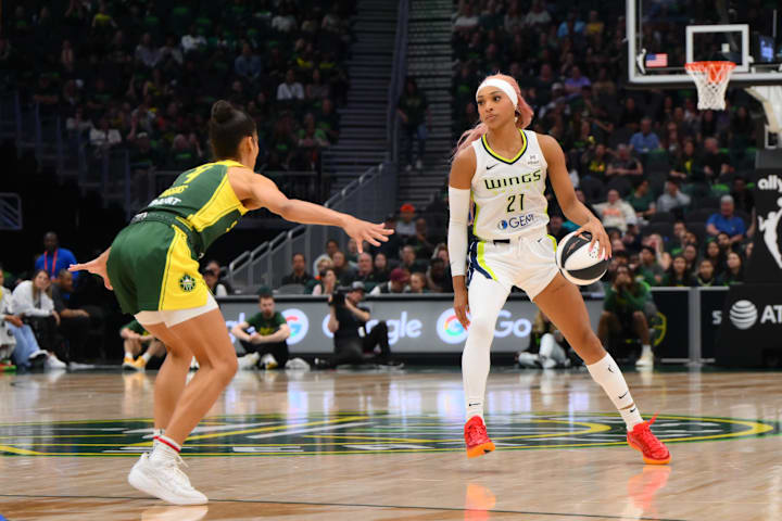 Dallas Wings guard DiJonai Carrington dribbles the ball while guarded by Seattle Storm guard Skylar Diggins.