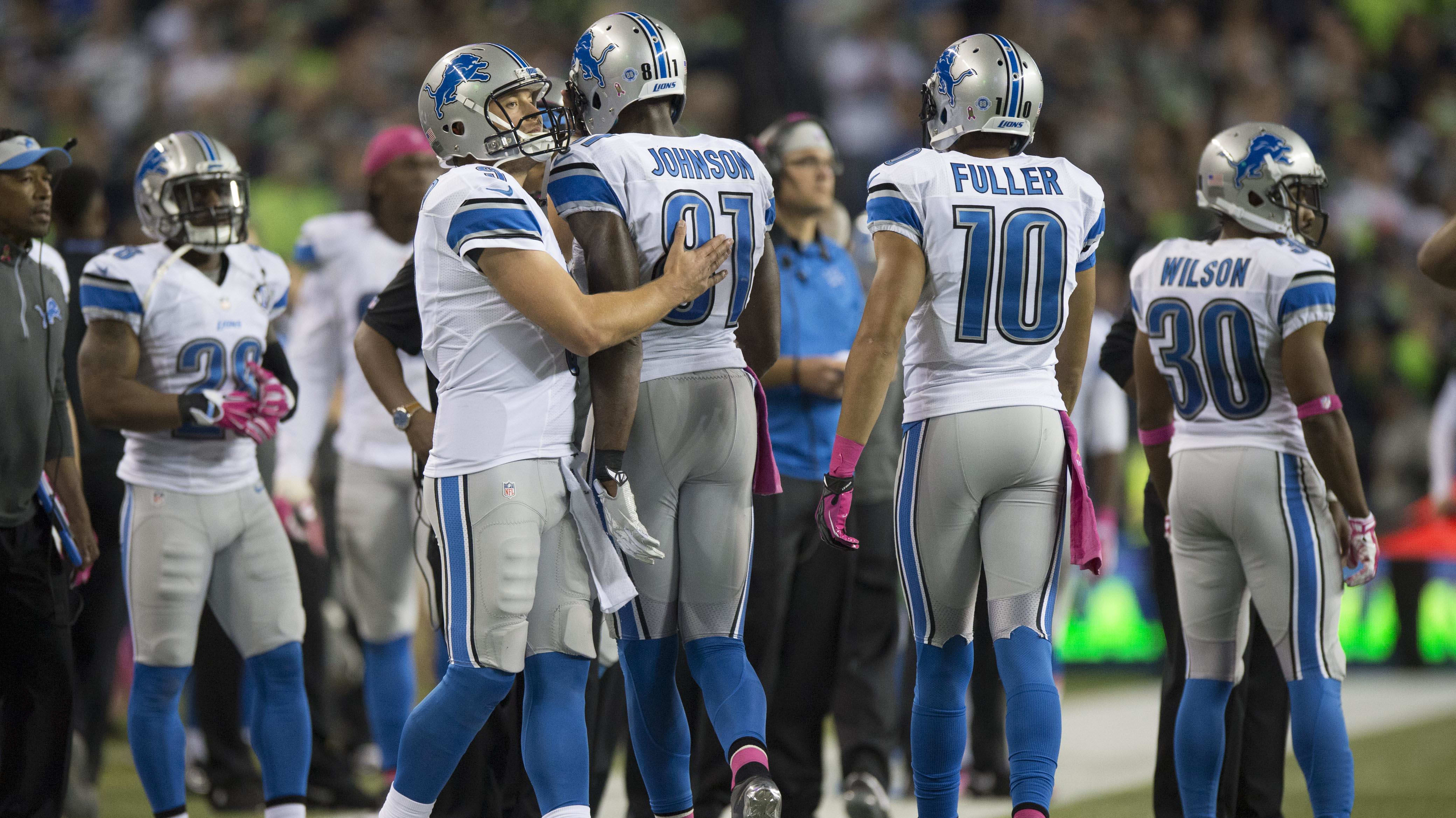 Detroit Lions quarterback Matthew Stafford (9) consoles wide receiver Calvin Johnson.