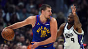 Nov 22, 2025; Denver, Colorado, USA; Denver Nuggets center Nikola Jokic (15) looks to pass the ball against Sacramento Kings forward Precious Achiuwa (9) during the second half at Ball Arena. Mandatory Credit: Christopher Hanewinckel-Imagn Images