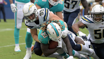 Los Angeles Chargers defensive end Joey Bosa (99) tackles Miami Dolphins running back Jay Ajayi (23)  during a NFL football game at StubHub Center in 2017.