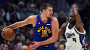 Nov 22, 2025; Denver, Colorado, USA; Denver Nuggets center Nikola Jokic (15) looks to pass the ball against Sacramento Kings forward Precious Achiuwa (9) during the second half at Ball Arena. Mandatory Credit: Christopher Hanewinckel-Imagn Images