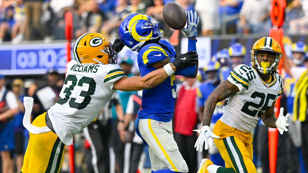 Oct 6, 2024; Inglewood, California, USA; Green Bay Packers safety Evan Williams (33) breaks up a pass to Los Angeles Rams wide receiver Tutu Atwell (5) during the third quarter at SoFi Stadium. Right is Green Bay Packers cornerback Keisean Nixon (25).  Mandatory Credit: Robert Hanashiro-Imagn Images