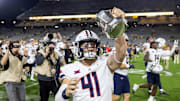 Nov 28, 2025; Tempe, Arizona, USA; Arizona Wildcats long snapper Avery Salerno (41) celebrates with the Territorial Cup trophy after defeating the Arizona State Sun Devils in the 99th Territorial Cup at Mountain America Stadium. Mandatory Credit: Mark J. Rebilas-Imagn Images