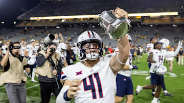 Nov 28, 2025; Tempe, Arizona, USA; Arizona Wildcats long snapper Avery Salerno (41) celebrates with the Territorial Cup trophy after defeating the Arizona State Sun Devils in the 99th Territorial Cup at Mountain America Stadium. Mandatory Credit: Mark J. Rebilas-Imagn Images