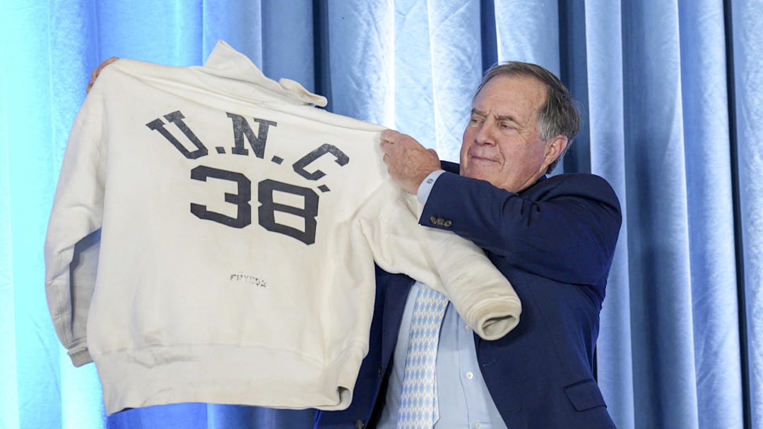 Dec 12, 2024; Chapel Hill, NC, USA;  North Carolina Tar Heels new head coach Bill Belichick holds up the sweatshirt worn by his father when he was an assistant coach at New North Carolina Tar Heels new at Loudermilk Center for Excellence. Mandatory Credit: Jim Dedmon-Imagn Images