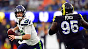 Nov 16, 2025; Inglewood, California, USA; Seattle Seahawks quarterback Sam Darnold (14) rolls out to pass against Los Angeles Rams defensive tackle Poona Ford (95) during the second half at SoFi Stadium. Mandatory Credit: Gary A. Vasquez-Imagn Images