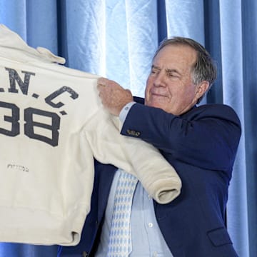 Dec 12, 2024; Chapel Hill, NC, USA;  North Carolina Tar Heels new head coach Bill Belichick holds up the sweatshirt worn by his father when he was an assistant coach at New North Carolina Tar Heels new at Loudermilk Center for Excellence. Mandatory Credit: Jim Dedmon-Imagn Images