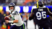 Nov 16, 2025; Inglewood, California, USA; Seattle Seahawks quarterback Sam Darnold (14) rolls out to pass against Los Angeles Rams defensive tackle Poona Ford (95) during the second half at SoFi Stadium. Mandatory Credit: Gary A. Vasquez-Imagn Images
