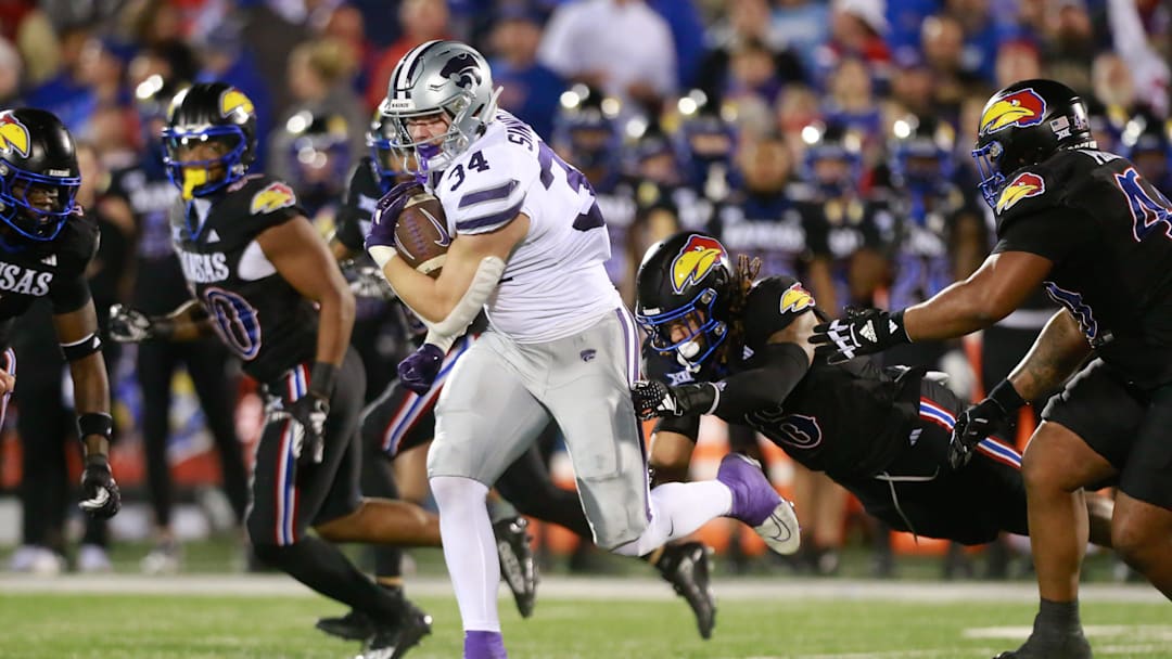 Kansas State junior tight end Ben Sinnott (34) drives through Kansas defenders during the first quarter of Saturday's Sunflower Showdown against Kansas inside David Booth Kansas Memorial Stadium.