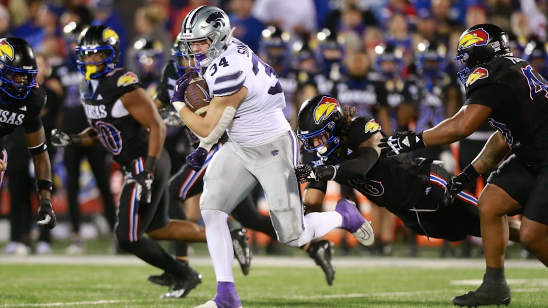 Kansas State junior tight end Ben Sinnott (34) drives through Kansas defenders during the first