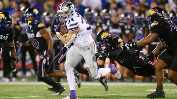 Kansas State junior tight end Ben Sinnott (34) drives through Kansas defenders during the first