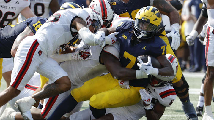 Sep 14, 2024; Ann Arbor, Michigan, USA;  Michigan Wolverines running back Donovan Edwards (7) is tackled by Arkansas State Red Wolves safety Dontay Joyner (6) during the first half at Michigan Stadium. Mandatory Credit: Rick Osentoski-Imagn Images