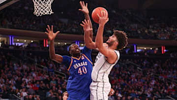 Nov 18, 2025; New York, New York, USA; Duke Blue Devils forward Cameron Boozer (12) shoots the ball as Kansas Jayhawks forward Flory Bidunga (40) defends during the second half at Madison Square Garden. Mandatory Credit: Vincent Carchietta-Imagn Images