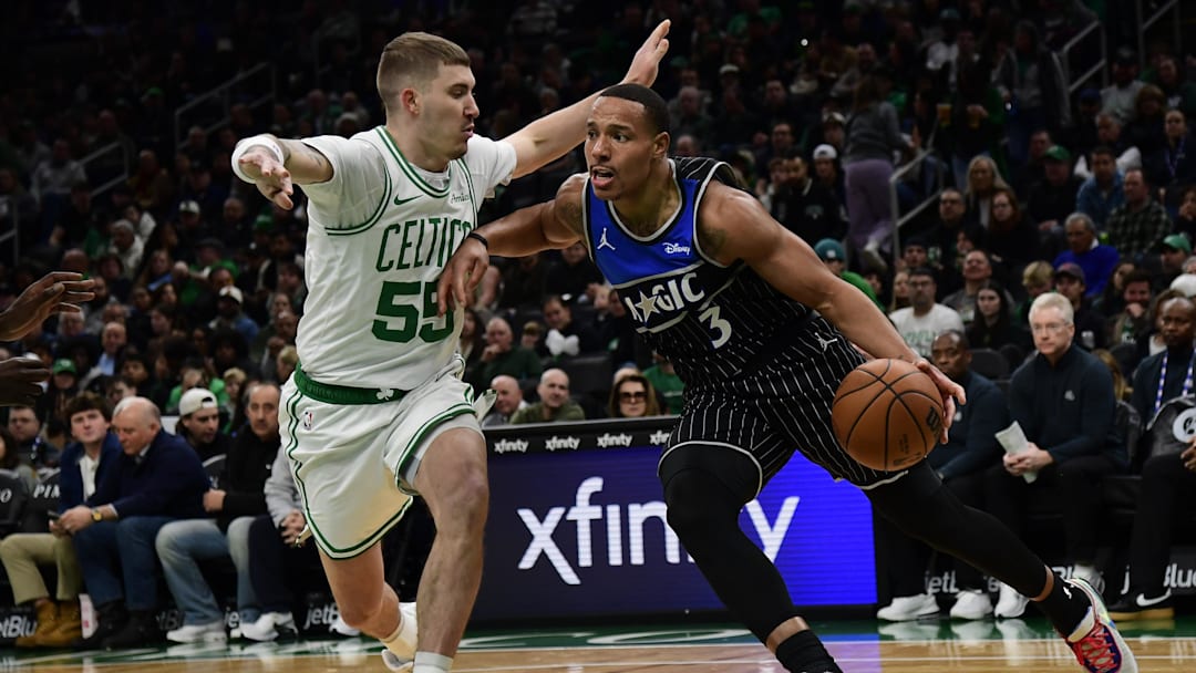 Nov 23, 2025; Boston, Massachusetts, USA; Orlando Magic guard Desmond Bane (3) controls the ball while Boston Celtics guard Baylor Scheierman (55) defends during the first half at TD Garden. Mandatory Credit: Bob DeChiara-Imagn Images