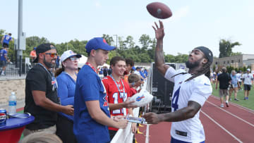 Bills running back James Cook throws a football back to a fan in the stands after autographing the ball during the opening day of Buffalo Bills training camp.