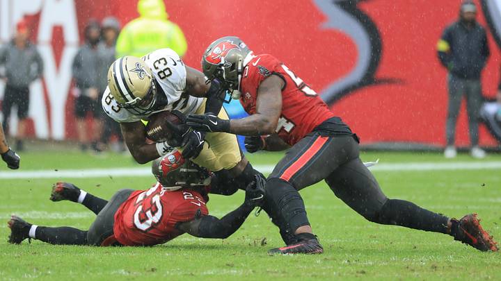Dec 7, 2025; Tampa, Florida, USA; New Orleans Saints tight end Juwan Johnson (83) is tackled by Tampa Bay Buccaneers safety Tykee Smith (23) and linebacker Lavonte David (54) during the second quarter at Raymond James Stadium. Mandatory Credit: Kim Klement Neitzel-Imagn Images