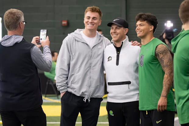 Denver Broncos quarterback Bo Nix, a former Oregon quarterback, left, and Oregon quarterback Dillon Gabriel, right, take a pi