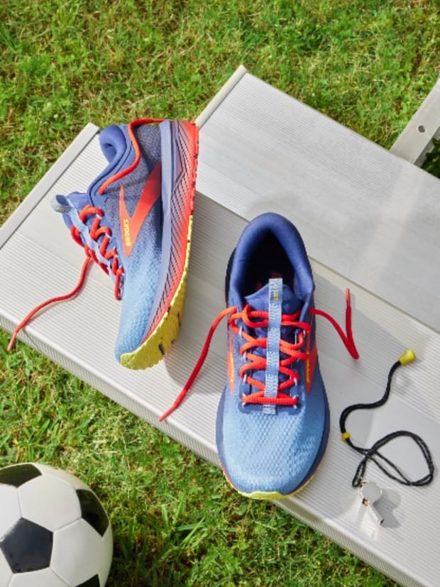 Blue Brooks Running shoes sit on bleachers.