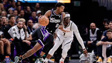 Feb 28, 2024; Denver, Colorado, USA; Sacramento Kings guard Malik Monk (0) controls the ball as Denver Nuggets guard Reggie Jackson (7) guards in the second quarter at Ball Arena. Mandatory Credit: Isaiah J. Downing-Imagn Images
