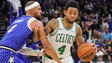 Nov 9, 2025; Orlando, Florida, USA; Boston Celtics guard Anfernee Simons (4) drives past Orlando Magic guard Jalen Suggs (4) during the second quarter at Kia Center.