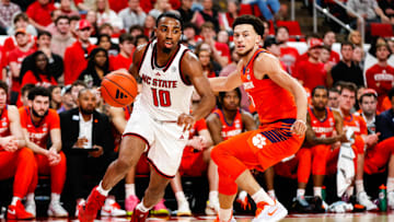Feb 1, 2025; Raleigh, North Carolina, USA; North Carolina State Wolfpack guard Marcus Hill (10) dribbles with the ball guarded by Clemson Tigers guard Chase Hunter (1) during the first half of the game at Lenovo Center.