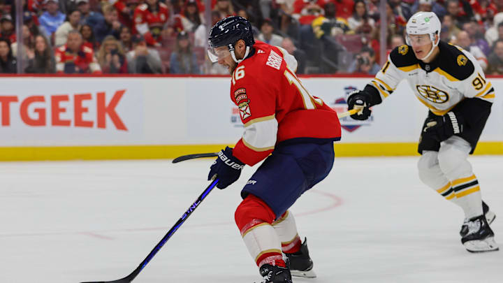 Oct 8, 2024; Sunrise, Florida, USA; Florida Panthers center Aleksander Barkov (16) moves the puck past Boston Bruins defenseman Nikita Zadorov (91) during the second period at Amerant Bank Arena. Mandatory Credit: Sam Navarro-Imagn Images