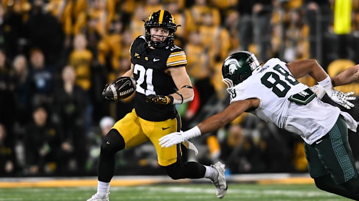 Nov 22, 2025; Iowa City, Iowa, USA; Iowa Hawkeyes wide receiver Kaden Wetjen (21) returns a punt as Michigan State Spartans tight end Kai Rios (88) attempts to make the tackle during the fourth quarter at Kinnick Stadium. Mandatory Credit: Jeffrey Becker-Imagn Images