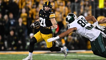 Nov 22, 2025; Iowa City, Iowa, USA; Iowa Hawkeyes wide receiver Kaden Wetjen (21) returns a punt as Michigan State Spartans tight end Kai Rios (88) attempts to make the tackle during the fourth quarter at Kinnick Stadium. Mandatory Credit: Jeffrey Becker-Imagn Images