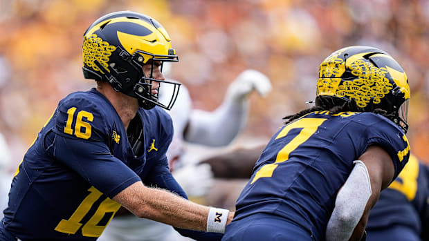 Michigan quarterback Davis Warren (16) hands the ball to running back Donovan Edwards (7) against Texas during the second hal