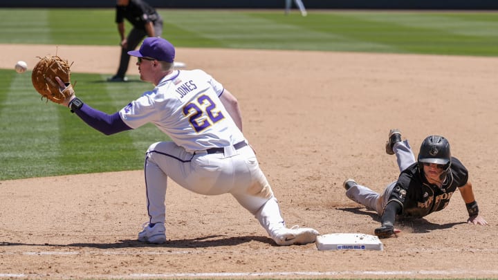 May 31, 2024; Chapel Hill, NC, USA; LSU first baseman Jared Jones (22) tries to catch Wofford infielder Brice Martinez (10) during the NCAA Regional in Chapel Hill. Mandatory Credit: Jim Dedmon-USA TODAY Sports