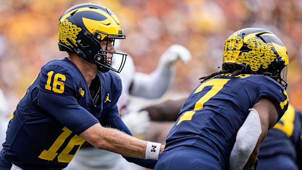 Michigan quarterback Davis Warren (16) hands the ball to running back Donovan Edwards (7) against Texas 