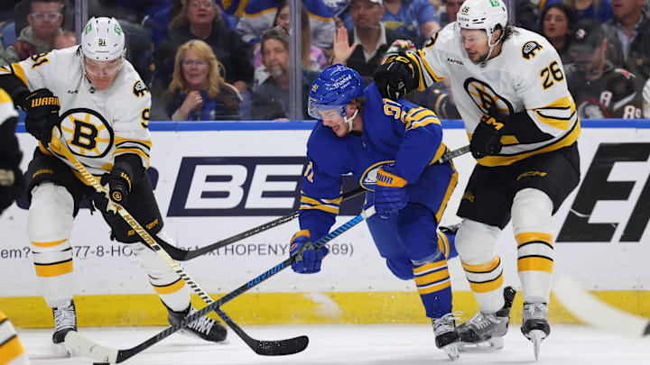 Apr 28, 2026; Buffalo, New York, USA; Buffalo Sabres right wing Josh Doan (91) controls the puck as Boston Bruins defenseman Andrew Peeke (26) defends during overtime in game five of the first round of the 2026 Stanley Cup Playoffs at KeyBank Center. Mandatory Credit: Timothy T. Ludwig-Imagn Images