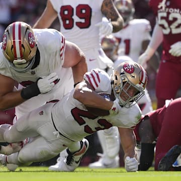 Sep 21, 2025; Santa Clara, California, USA; San Francisco 49ers running back Christian McCaffrey (23) carries the ball as he is tackled by. Arizona Cardinals defensive lineman Darius Robinson (56) during the second half at Levi's Stadium. Mandatory Credit: Kyle Terada-Imagn Images