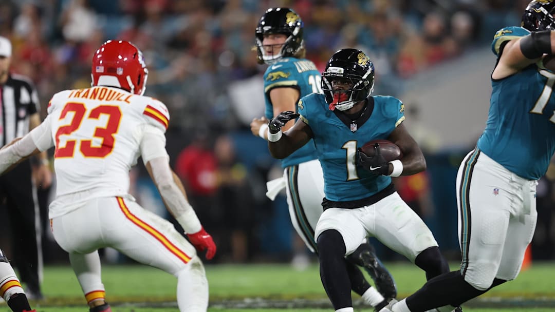 Oct 6, 2025; Jacksonville, Florida, USA; Jacksonville Jaguars running back Travis Etienne (1) runs against Kansas City Chiefs linebacker Drue Tranquill (23) during the first quarter at EverBank Stadium. Mandatory Credit: Morgan Tencza-Imagn Images