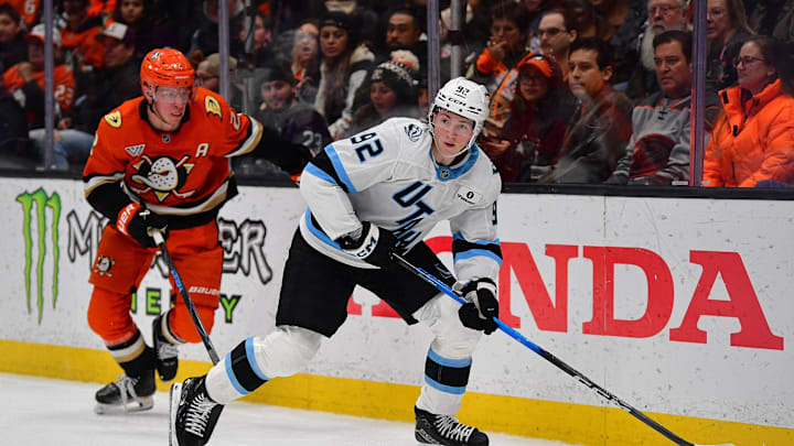 Dec 3, 2025; Anaheim, California, USA; Utah Mammoth center Logan Cooley (92) moves the puck ahead of Anaheim Ducks defenseman Jackson Lacombe (2) during the second period at Honda Center. Mandatory Credit: Gary A. Vasquez-Imagn Images