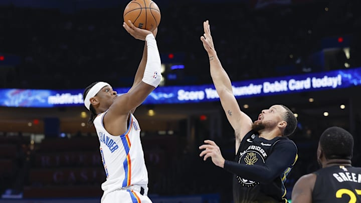 Oklahoma City Thunder guard Shai Gilgeous-Alexander (2) shoots as Golden State Warriors guard Stephen Curry (30) defends.