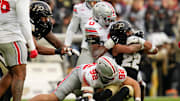 Ohio State Buckeyes linebacker Sonny Styles (0) and Ohio State Buckeyes defensive end Caden Curry (92) tackle Purdue Boilermakers running back Antonio Harris (22) during the NCAA football game at Ross-Ade Stadium in West Lafayette, Ind. on Nov. 8, 2025. Ohio State won 34-10.